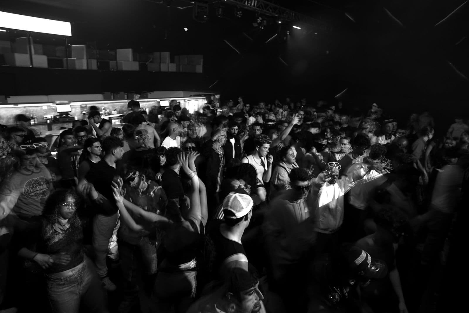 A packed, dimly lit club crowd mid-night